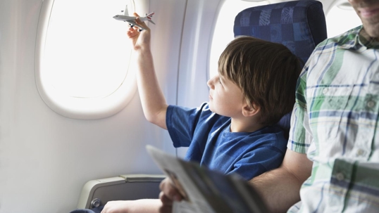 little boy flying a toy plane