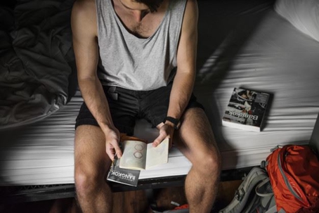 man sitting on bed reading a brochure