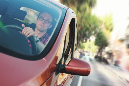man driving in a red car